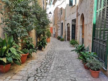 enge Gasse mit Blumentöpfen in Sòller